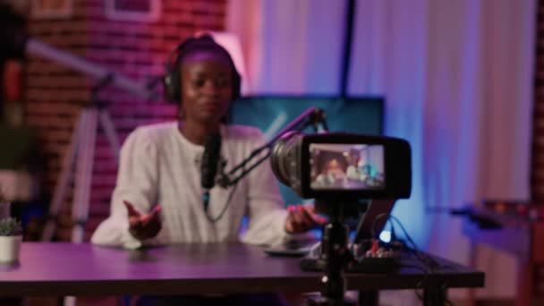 Selective focus on african american woman influencer talking in front of digital camera recording vlog – Stock-video