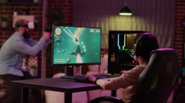 Gamer girl shocked after losing fast paced space shooter while boyfriend is enjoying virtual reality role playing game