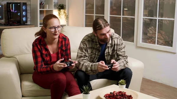 Чоловік і жінка сидять на дивані грають у відеоігри — стокове фото