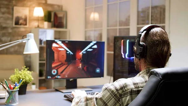 Profi-Gamer mit langen Haaren setzt Kopfhörer mit Mikrofon auf — Stockfoto