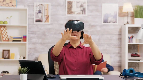 Retired senior woman amazed while using virtual reality goggles — Stock Photo, Image