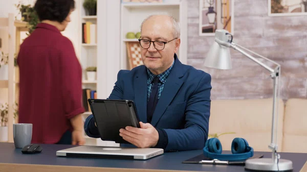 Elederly man använder tablett när du sätter dig på kontoret — Stockfoto