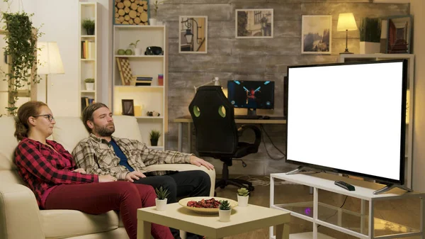 Пара отдыха на диване смотреть по телевизору с зеленым экраном — стоковое фото