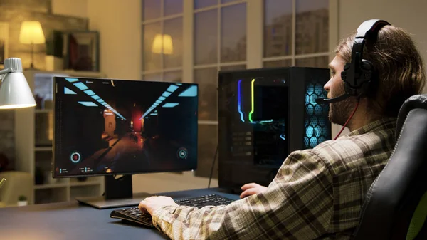 Kulaklıklı bir erkek çevrimiçi video oyunları oynuyor — Stok fotoğraf