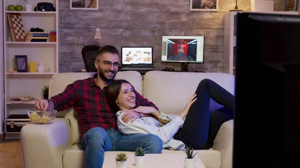 Casal encantador deitado no sofá assistindo a um filme — Fotografia de Stock