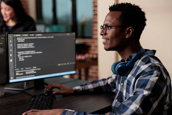 Улыбка уверенного африканского инженера-программиста, разрабатывающего алгоритм машинного обучения — стоковое фото