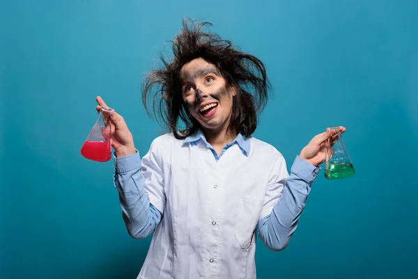 Crazy chemist acting dumb while having glassware beakers filled with liquid substances. — Stockfoto