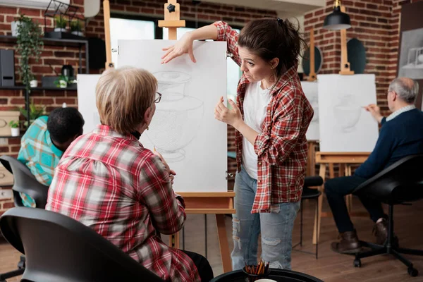 Art teacher helping senior student to develop sketching technique — Foto Stock