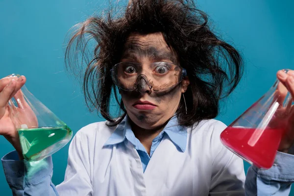 Confused silly chemistry expert holding glass jars filled with toxic chemical liquid substances — 스톡 사진