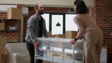 Yeni gayrimenkul eşyalarının paketlerini açan evli eşler.