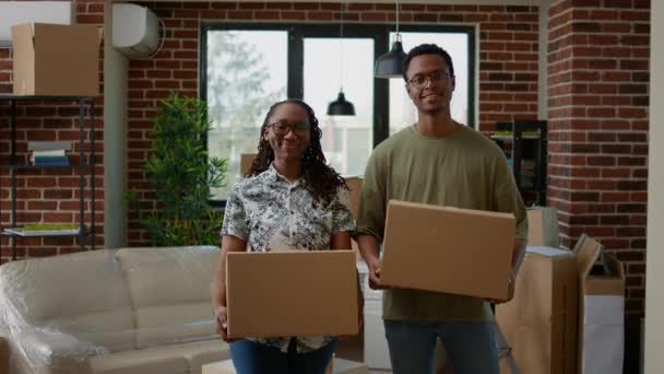 Portrait of african american couple holding cardboard boxes — ストック動画