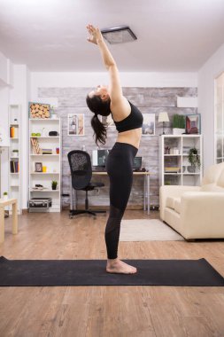 Güneş yogası yapan genç bir kadının yan görüntüsü
