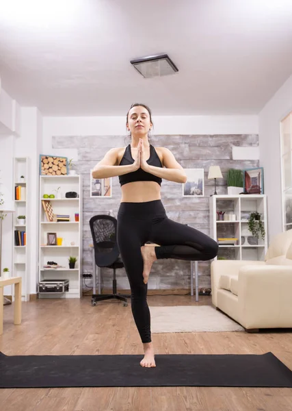 Bruna donna sorridente mentre fa yoga posa — Foto Stock