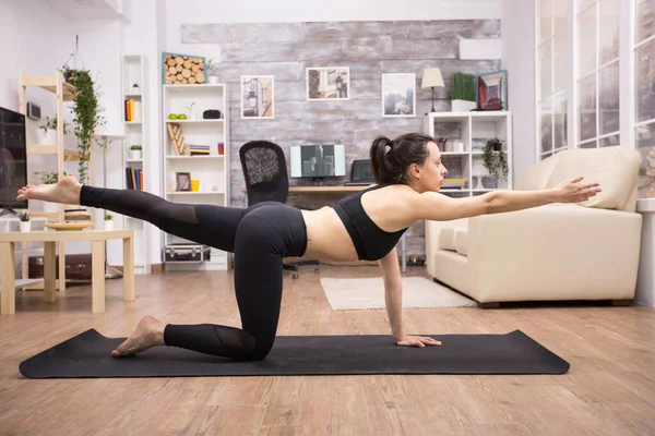 Fit adult woman in sportswear doing yoga pose — Foto Stock