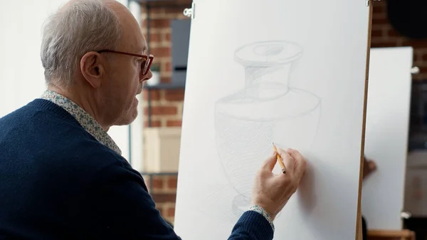 Anciano estudiante usando lápiz para dibujar modelo de jarrón en papel —  Fotos de Stock
