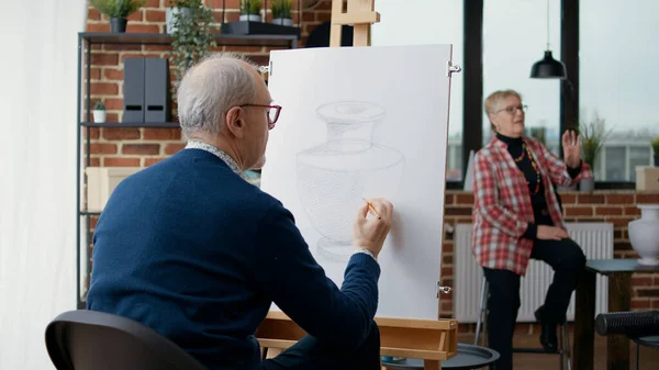 美術の授業でキャンバスに花瓶のモデルを描く高齢者 — ストック写真