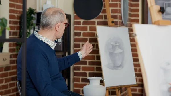 Artista sênior mostrando modelo de vaso para pessoas que frequentam a prática da oficina — Fotografia de Stock