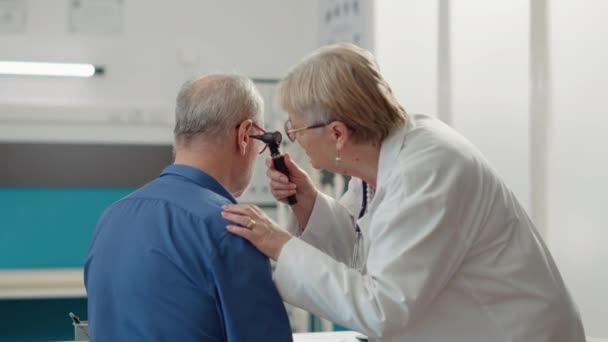Спеціаліст з отлорингології використовує отоскоп для вивчення інфекції вух. — стокове відео