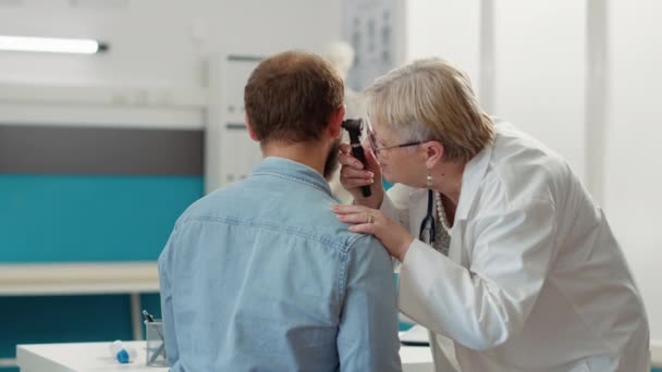 Otorrinolaringologista feminino consulta paciente em armário médico — Vídeo de Stock