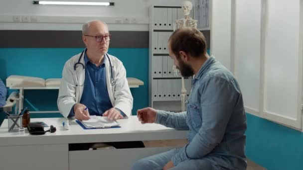 Médico masculino dando papel de prescrição para pessoa doente — Vídeo de Stock