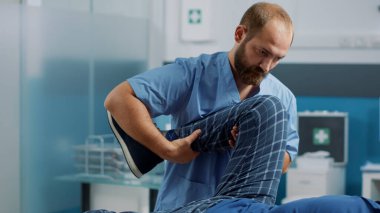 Erkek osteopat kemik kırıyor ve bacak kasları geriliyor.