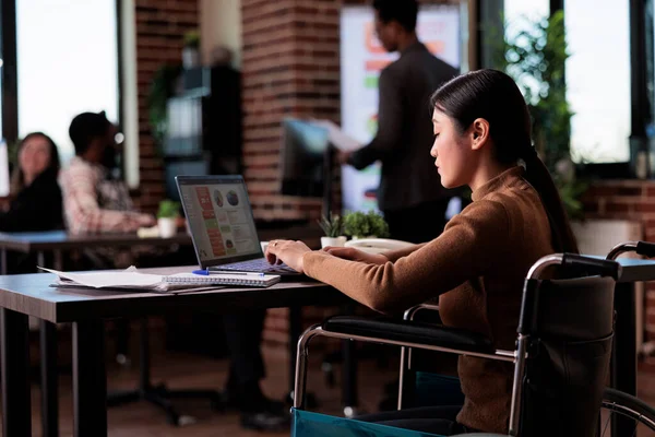 Employé de bureau ayant une incapacité chronique travaillant sur un ordinateur portable — Photo