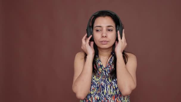 Indian woman having fun listening to music on headphones — стокове відео