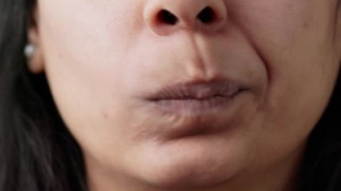Macro shot of young adult moving lips and mouth in studio