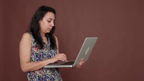 Happy female model holding laptop computer on camera — Vídeo de Stock