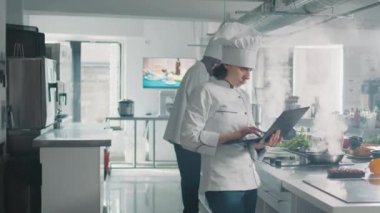 Female cook studying professional food recipe on laptop