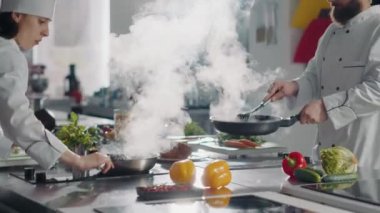 Erkek aşçı, gurme yemeği için sebze buğulama tavası kullanıyor.