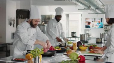 Man chef frying beef meat piece on stove in professional kitchen