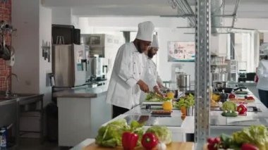 Afrika kökenli Amerikalı şef kesme tahtasında taze kereviz dilimliyor.