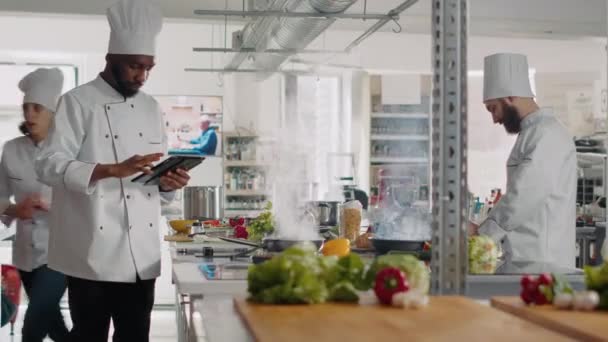 Cozinheiro afro-americano olhando para a receita on-line no tablet digital — Vídeo de Stock