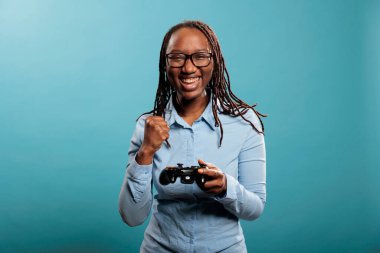 Excited happy woman playing videogames on console while celebrating match victory.