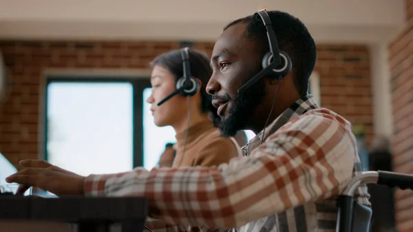 Male worker answering phone call on audio headset at customer service — Foto Stock