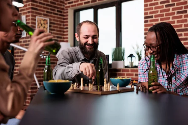 Laughing diverse friends sitting together at home while playing strategy boardgames. — Foto de Stock