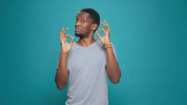 Male model showing okay gesture with fingers in front of camera — Stock Photo, Image