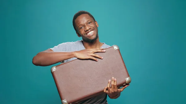 Hombre feliz sosteniendo maleta sintiéndose emocionado con el viaje de vacaciones —  Fotos de Stock