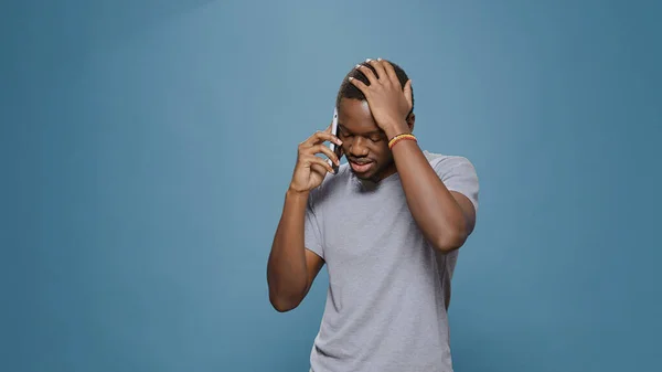 Millennial man talking on smartphone call over blue background — Φωτογραφία Αρχείου