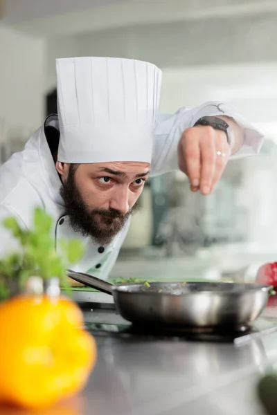 Master cook putting parmesan cheese in food while preparing meal for dinner service at restaurant. – stockfoto