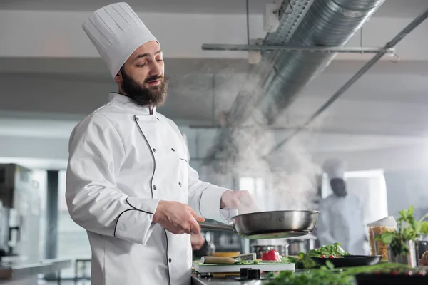 Experto en gastronomía con uniforme de cocina mientras cocina delicioso plato gourmet para el servicio de cena. —  Fotos de Stock