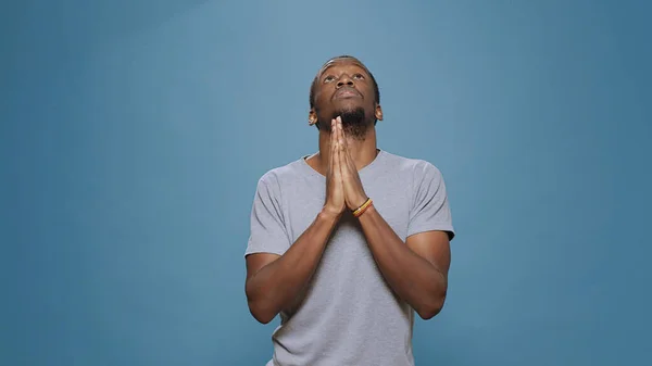 Modelo masculino de mãos dadas em oração para fazer sessão espiritual — Fotografia de Stock
