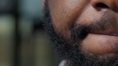 Makro erkek modelin dudaklarını oynatırken ve yüzünün yarısını gösterirken.