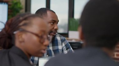 İş adamı, yönetim kurulu toplantısında meslektaşlarıyla konuşuyor.