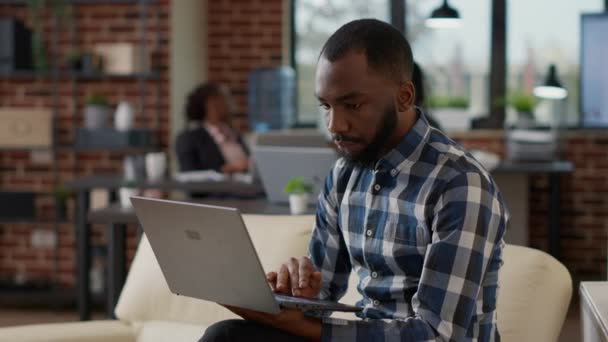 African american worker analyzing financial report on laptop — 비디오