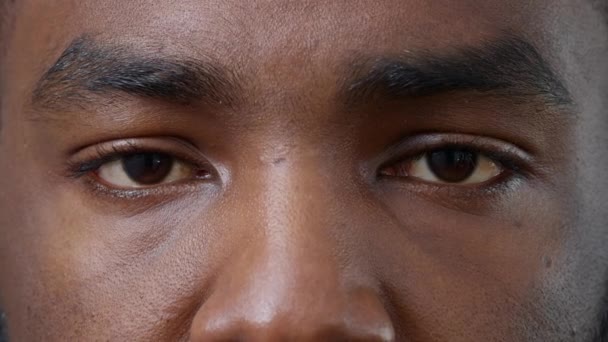 Makro ujęcie młodego mężczyzny pokazującego brązowe oczy przed kamerą — Wideo stockowe