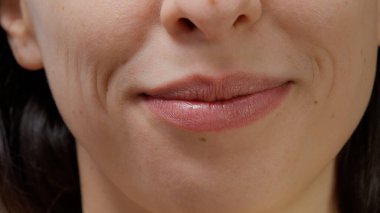 Macro shot of female model smiling and moving lips on camera