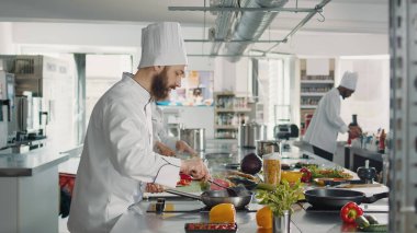 İtalyan yemeği pişirmek için tabakta parmesan peyniri rendeleyen erkek şef.