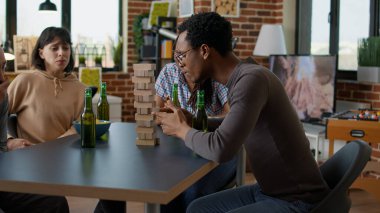 Erkekler ve kadınlar masa oyunu oynamak için evde toplanıyorlar.